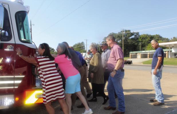 Members of the city staff including Mayor Lou Ann Berry, second from left, got involved in the ‘Push In’ Ceremony for new fire engine E-1 Sept. 17. Photo by Susan Harris