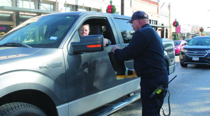 Firefighter Justin Solsbery expresses his appreciation to Andrea Zivney for giving a donation to ‘Christmas for Kids.’ This will help firefighters in the Canton area provide Christmas gifts to a child whose family is financially struggling during the holidays. Story on page 2A. Photo by Carla Gray