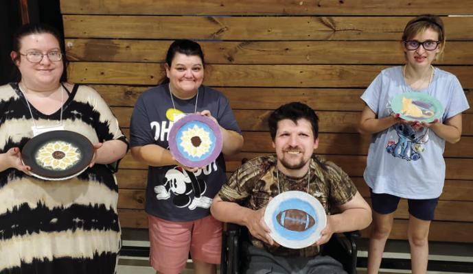 Adults with special needs enjoy painting on pottery