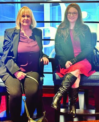 Denise York (left) and Catie Burgess pose in one of the mock-ups to simulate being on stage at the Dr. Phil show. Courtesy photo