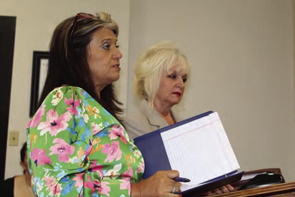 Van Zandt County Human Resource Coordinator Jessica Deville (foreground) and D’Ann Miller with Hibbs Hallmark of Tyler discussed the renewal of the county paid standard life insurance policy for VZC employees and retirees May 8 during the regular meeting of the VZC Commissioners Court. Photo by David Barber