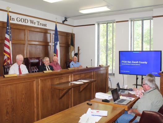 Van Zandt County Judge Andy Reese, second from left, discussed a proposal regarding fiscal year 2024 VZC Elected Officials’ Proposed Salaries through a power point presentation during the July 12 meeting of the VZC Commissioners Court. In a surprising result, Reese broke a 2-2 tie as he voted to deny the proposal. Photo by David Barber