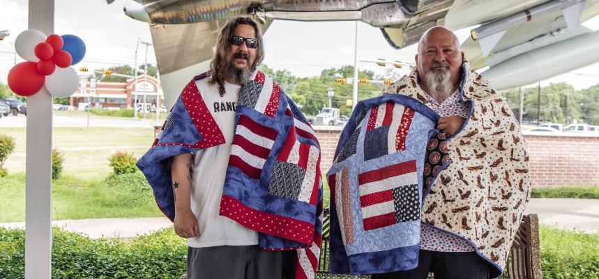 Van Zandt County 4-H members and two recipients for Quilts of Valor gathered at the VZC Veterans Memorial gazebo in Canton for a presentation of the quilts for the veterans. The recipients, Robert Alan Jackson, U.S. Marine Veteran, and Juan Herrera, Army Veteran are shown with their quilts. Story on page 9A. Photo by Faith Caughron