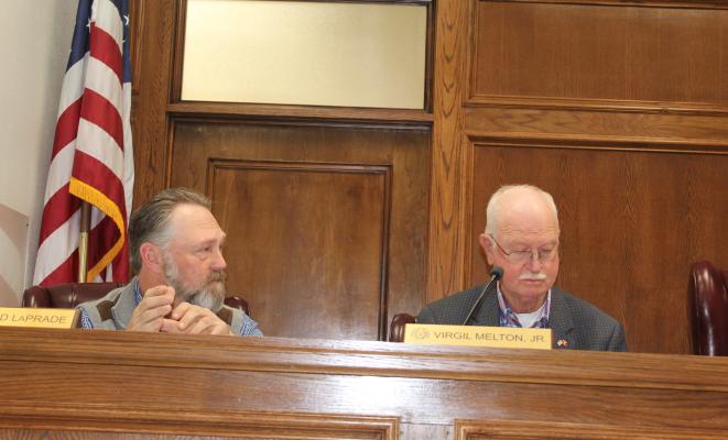 Van Zandt County Pct. 1 Commissioner Chad LaPrade (left) responds to a question about funding communication tower land and lease contracts from American Rescue Plan (ARP) interest funds March 21 during a special called meeting of the VZC Commissioners Court. Looking over the paperwork is VZC Pct. 2 Commissioner Virgil Melton Jr. Photo by David Barber