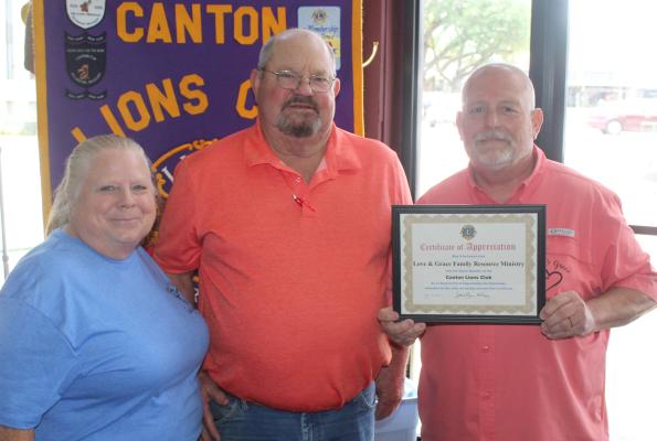 A ‘Certificate of Appreciation’ was presented to Dwayne Clements of Love &amp; Grace Family Resource Ministry of Canton, far right, by Canton Lions Club First Vice-President Sandy Sims following Clement’s presentation May 21 at the weekly Canton Lions Club Luncheon at Native Son located on the downtown square in Canton. Clements’ wife, Alice, far left, was also in attendance. Photo by David Barber