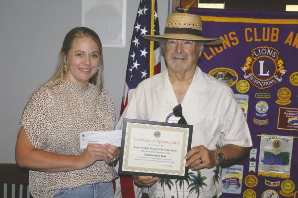 Following her presentation July 8 during the Canton Lions Club’s weekly luncheon at the Van Zandt Country Club, Lacye Welch, representing the ‘Project Stock the Classrooms’ organization, received a ‘Certificate of Appreciation’ from new Canton Lions Club President Doug Harrison. The Canton Lions Club members in attendance also voted to give the organization a $500.00 donation. Photo by David Barber