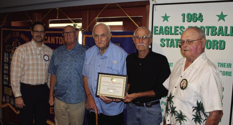 A ‘Certificate of Appreciation’ was presented by Canton Lions Club President Jonathan Helvey, far left, and Canton Lions Club Member Bob Giles, far right, to members of the 1964 Canton High School football team at the end of their presentation Sept. 25 during the weekly club luncheon at Van Zandt Country Club. Representing the team were left to right, defensive end David Miller, Head Coach Dean Hesse, and quarterback Mike Chambless. Photo by David Barber