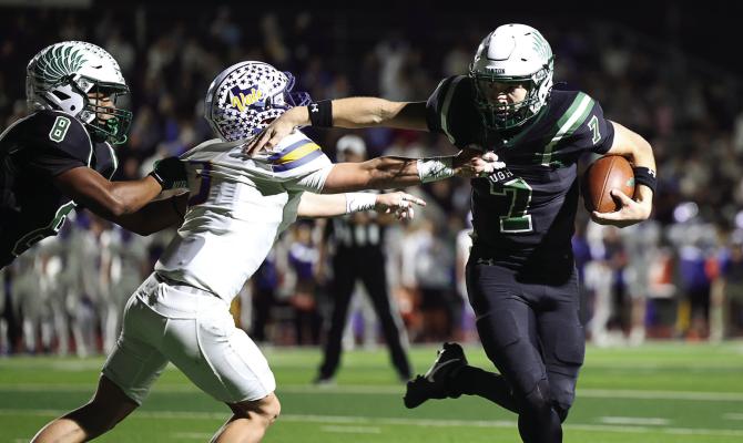 Canton Eagle quarterback Cort Ray (7) stiff arms a Sunnyvale tackler as he picks up yardage Nov. 7. Ray finished the game with 66 yards rushing on 18 carries and completed 17 out of 29 passes for 274 yards and a touchdown in Canton’s 56-24 loss at home. Photo by Don Johnson