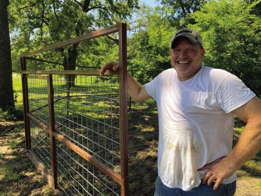 Steven Waugh setting up a hog trap in Luke’s neighbor’s yard. The flooded bottomland has pushed wild porkers to higher ground in search for food. Photo by Luke Clayton