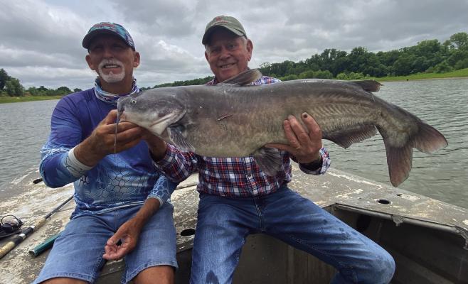 Guide J.C. McCullough (left) and Luke with a big blue catfish last week from the Red River below Lake Texoma. Photo by Jeff Rice