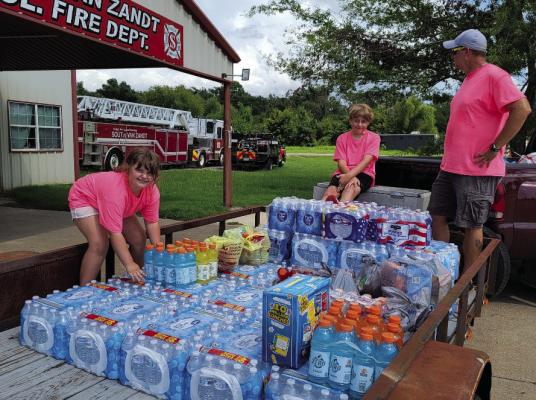 Grayson Weaver, 11, and his sister, Alice, 9, collected over 30 cases of bottled water and four cases of Gatorade in addition to some snack food items July 28 as they donated their collection to the South Van Zandt Fire Department. Assisting Grayson and Alice was their father, Billy Weaver. Photo by Susan Harris