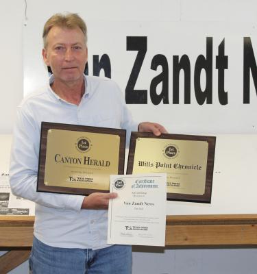 Van Zandt Newspapers L.L.C. Graphic Designer Tim Ball holds three awards won in the Texas Better Newspaper Contest sponsored by the Texas Press Association (TPA). Photo by David Barber
