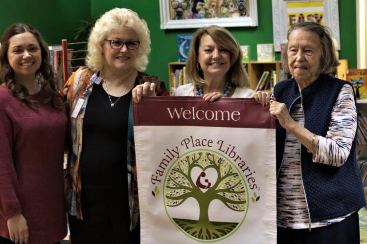Kathy Deerr presented the Van Zandt County Library with their official Family Place Library banner following her presentation on Thursday, Sept. 15. Accepting the award on the library’s behalf was Jordin Shilling, Tonja Garten, and Sarah Norman. Photo by Ethan Adams