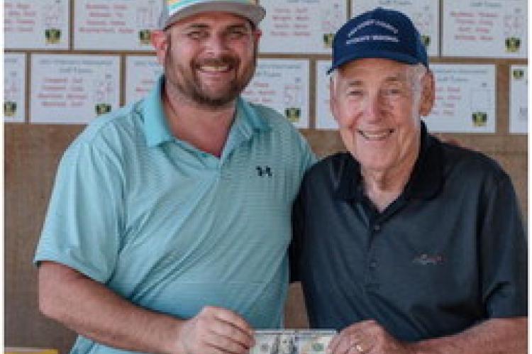 Michael Maxfi eld took home $100 for winning the closest to the pin competition at the VZ Veterans Memorial Golf Tournament. He was awarded his prize by Cary Hilliard. Photo by Faith Caughron