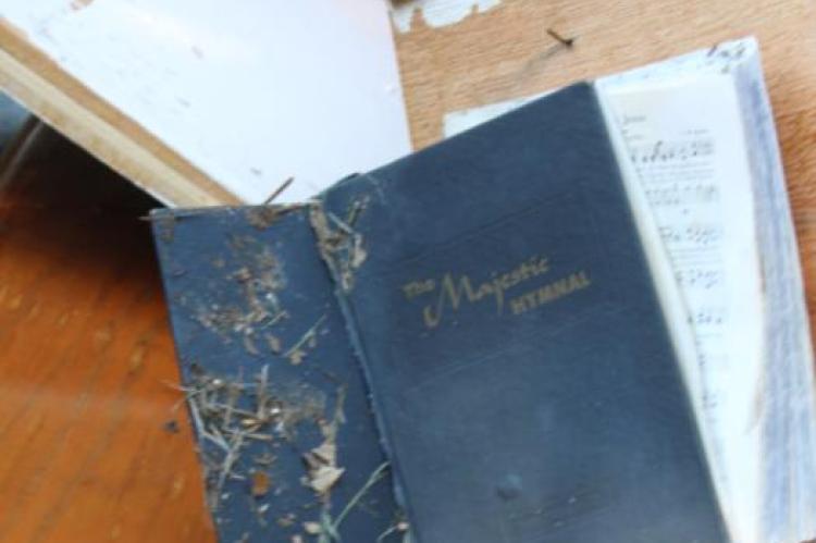 Left, a back view of the damage to the chapel. Above, a hymnal outside of Wesley Chapel Cemetery. Photos by Britne Hammons