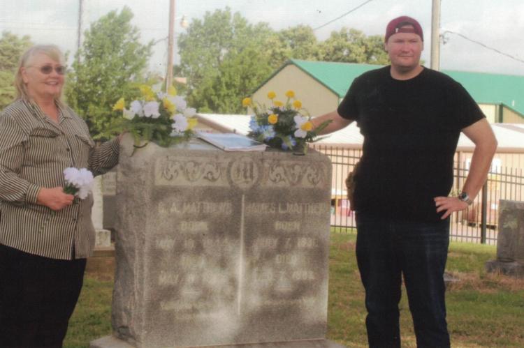 Mrs. Maloney and her son, Mark, stand at the grave of her ancestors, Dr. James Matthew and his wife, Georgia. Courtesy photo